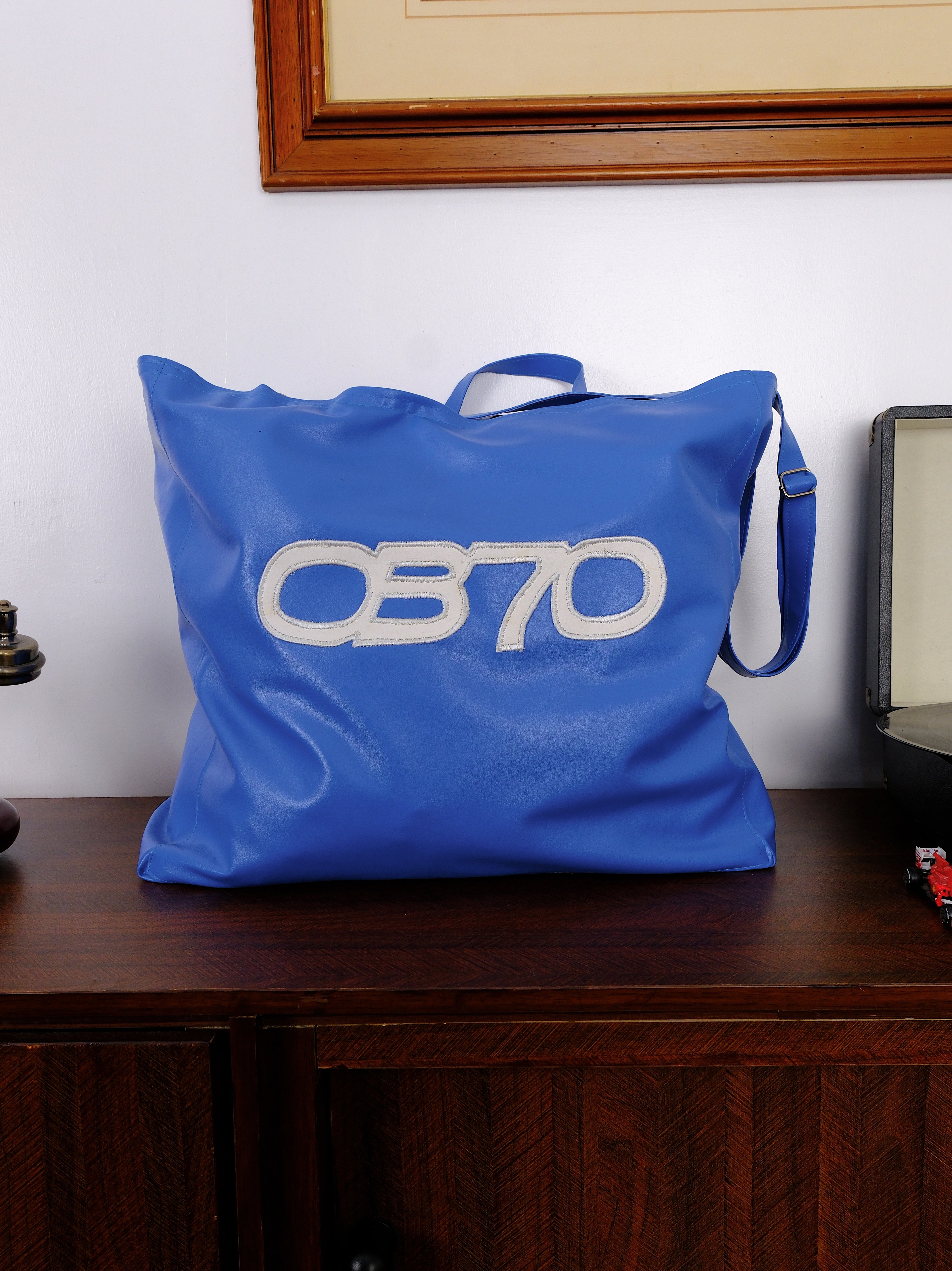 Blue bag with 'OB70' logo on a wooden surface