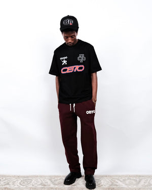 Person wearing a black OB70 '25 Championship T-shirt standing against a white background