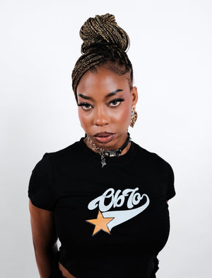 Woman wearing a black OB70 Summer '25 baby top on a white background