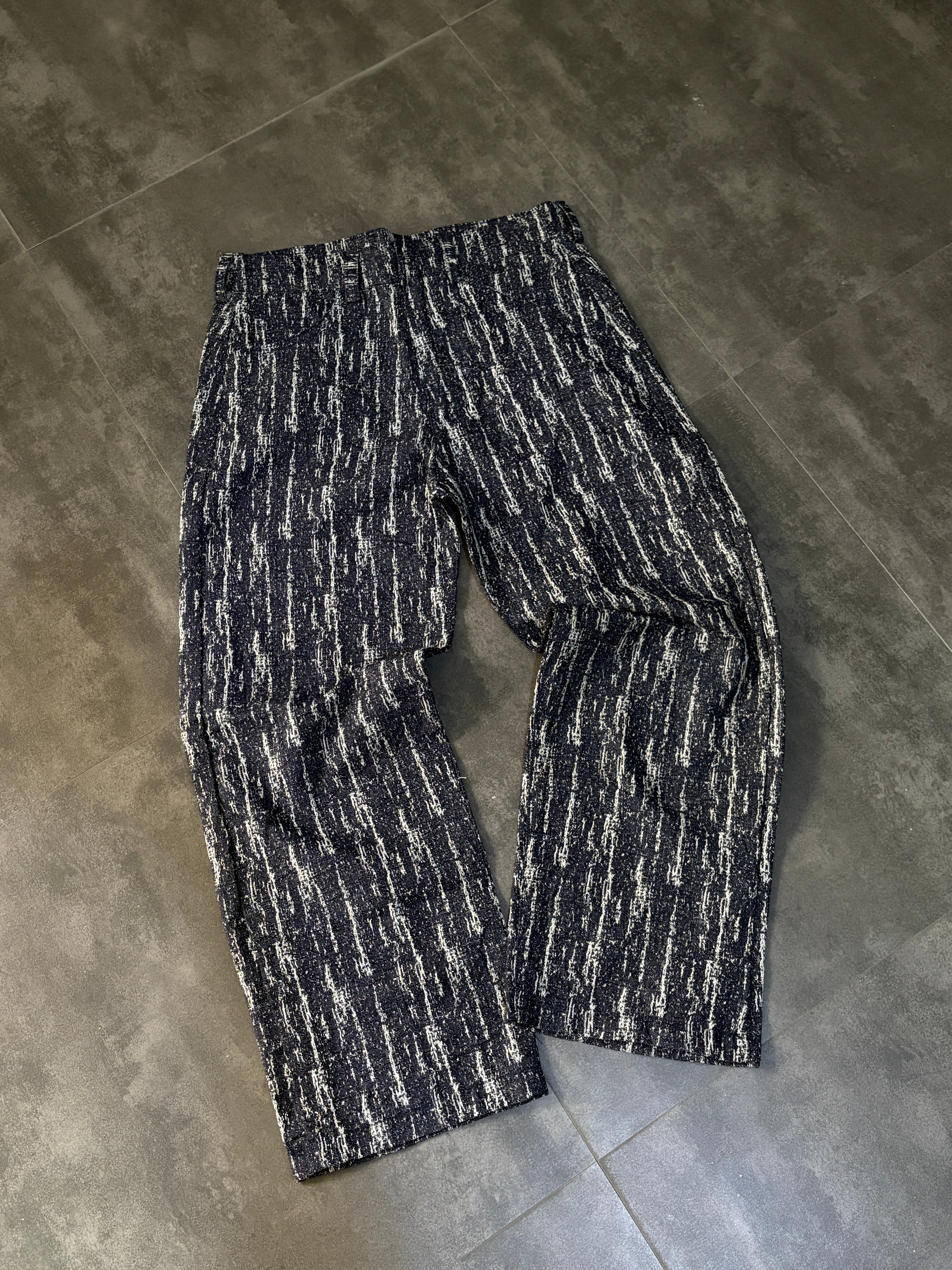 Black and white patterned pants on a gray tiled floor